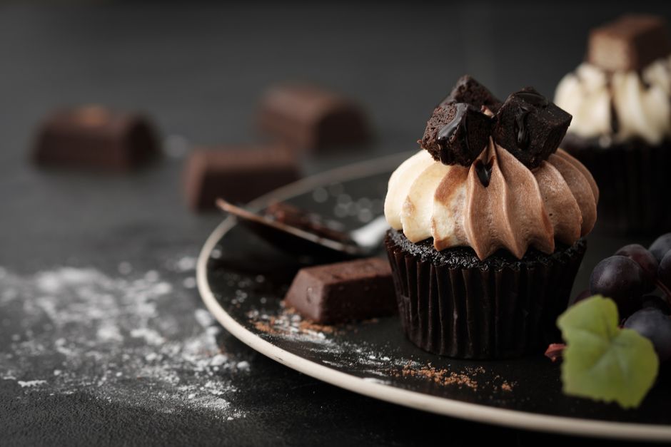 Decadent chocolate cupcake with rich cream and chocolate chunks, perfect for indulgence.