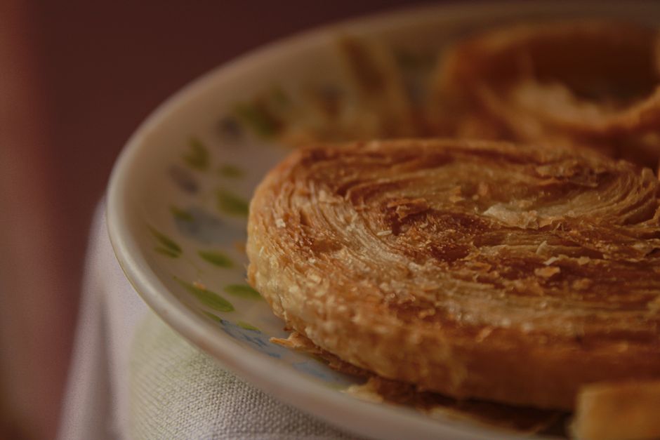 Warm, close-up image of a golden, flaky pastry on a patterned plate, ideal for breakfast themes.