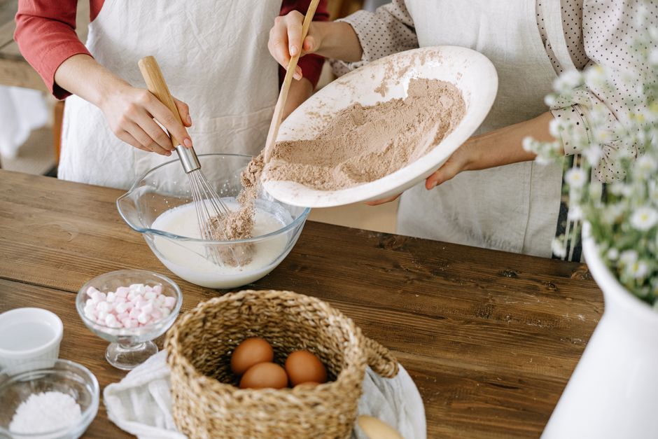 Baker sifting flour into a mixing bowl