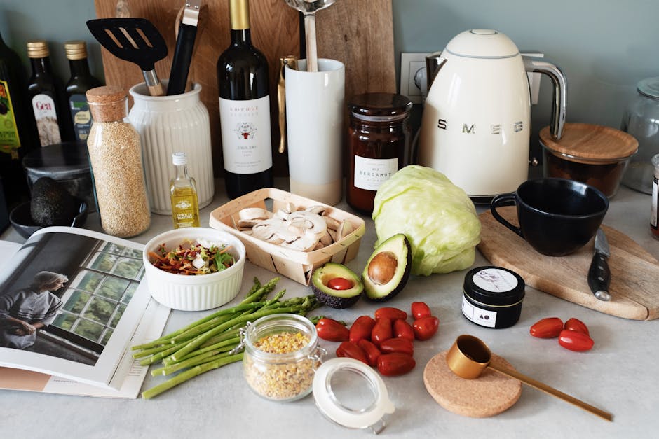 Assorted healthy food and vegetables set locating on gray countertop next to various utensils and appliances during cooking in stylish kitchen