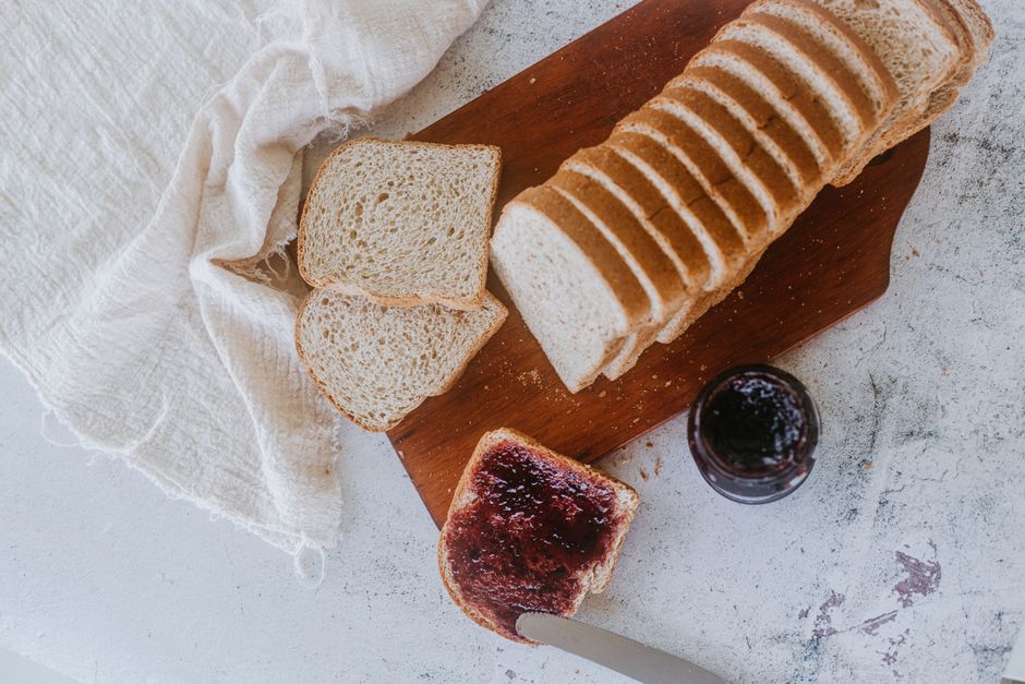Overhead view of sliced rustic bread and jam for breakfast.