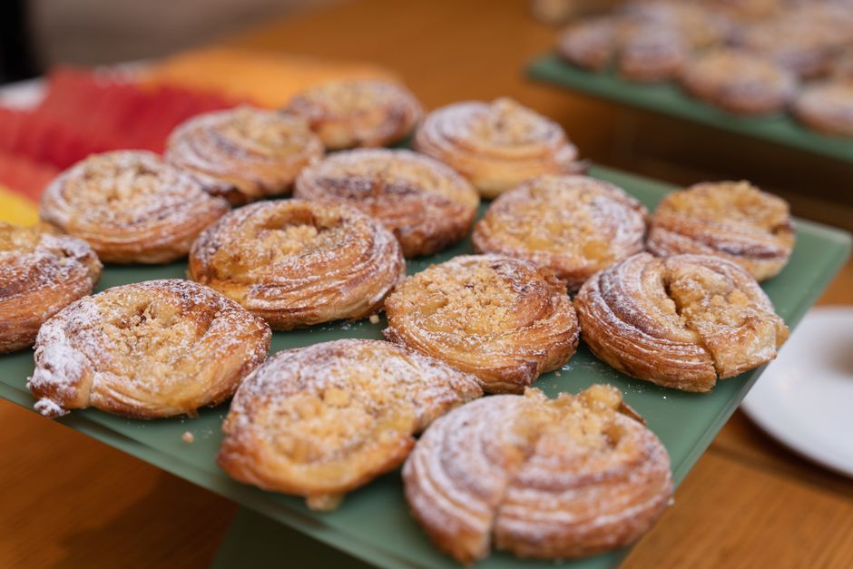 Tempting freshly baked pastries dusted with sugar, perfect for dessert lovers.