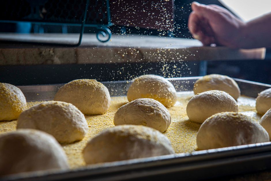 Dough balls proofing on a floured tray before baking