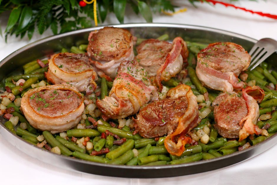 Delicious bacon-wrapped pork medallions served on a bed of seasoned green beans and beans.