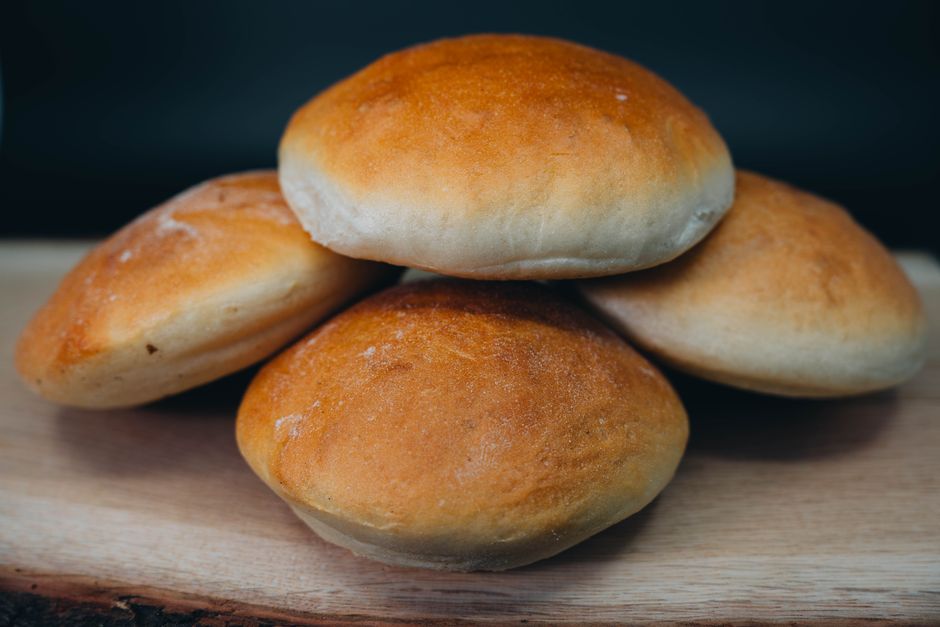 Golden brown buns stacked on a wooden board