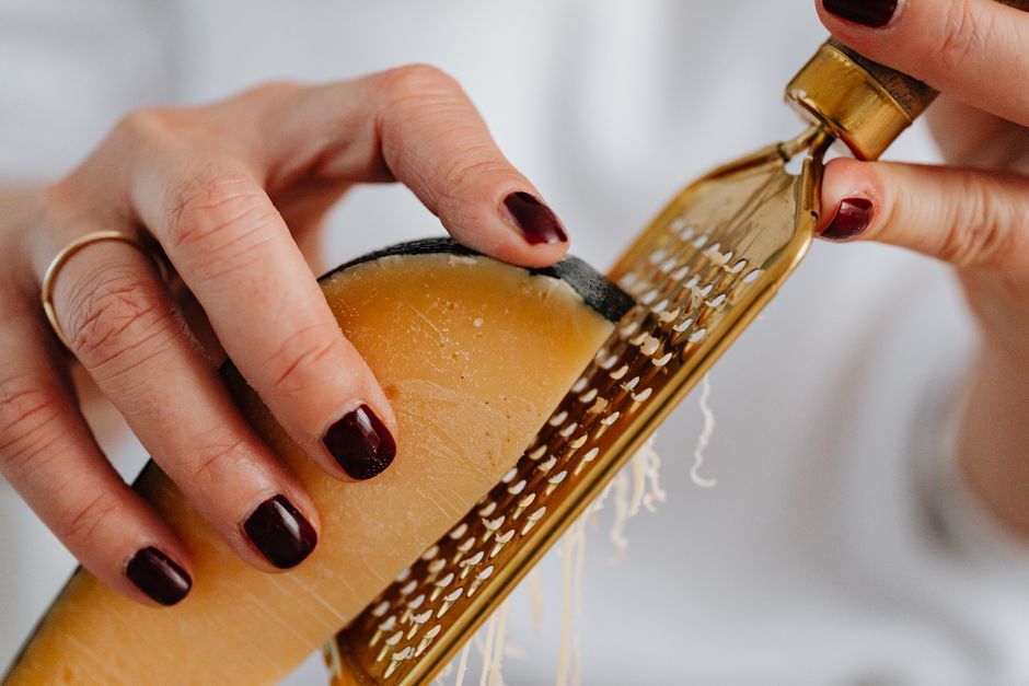 Hands grating hard cheese