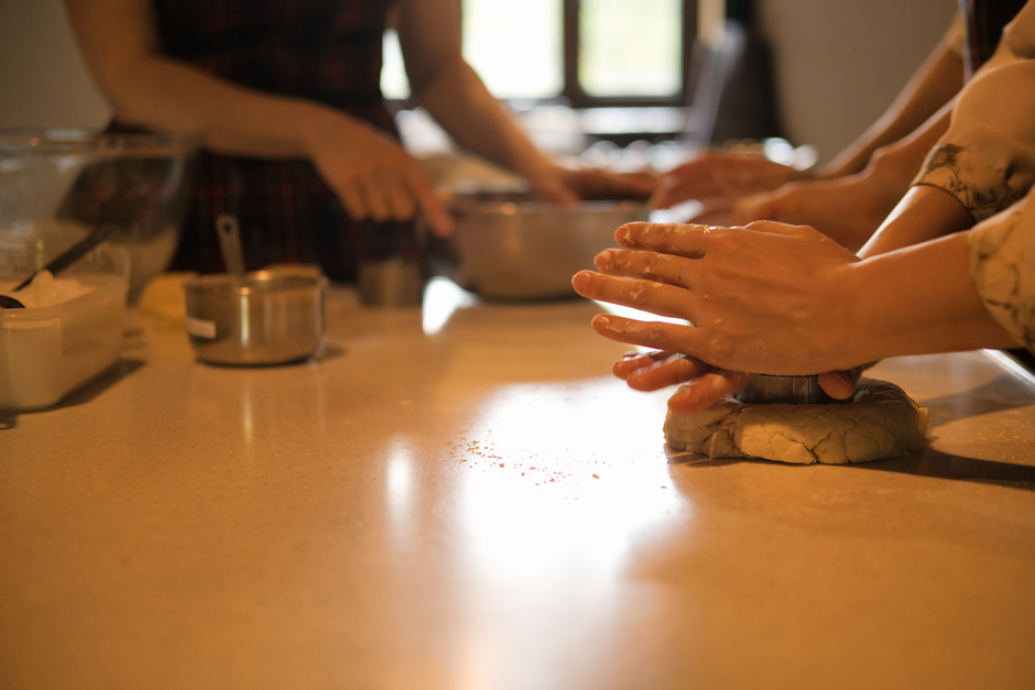 Hands kneading soft dough on a kitchen worktop