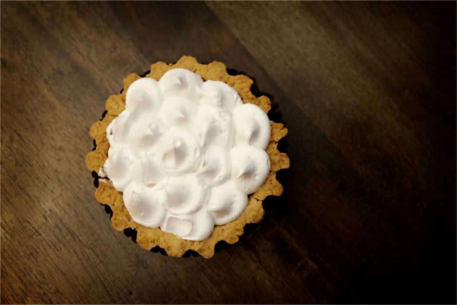 Tart with a whipped meringue-style topping on a wooden surface