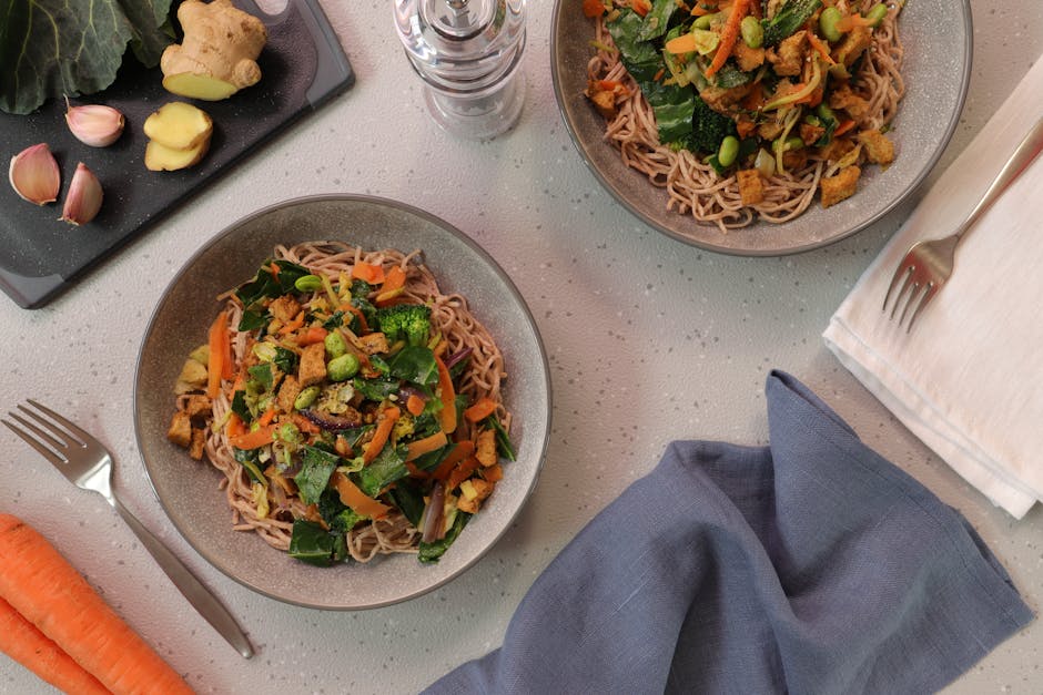 Top-down view of delicious vegetarian noodle bowls garnished with fresh vegetables.